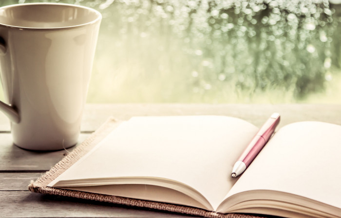 46750912 - pen on open notebook and coffee cup in rainy day window background, vintage filter